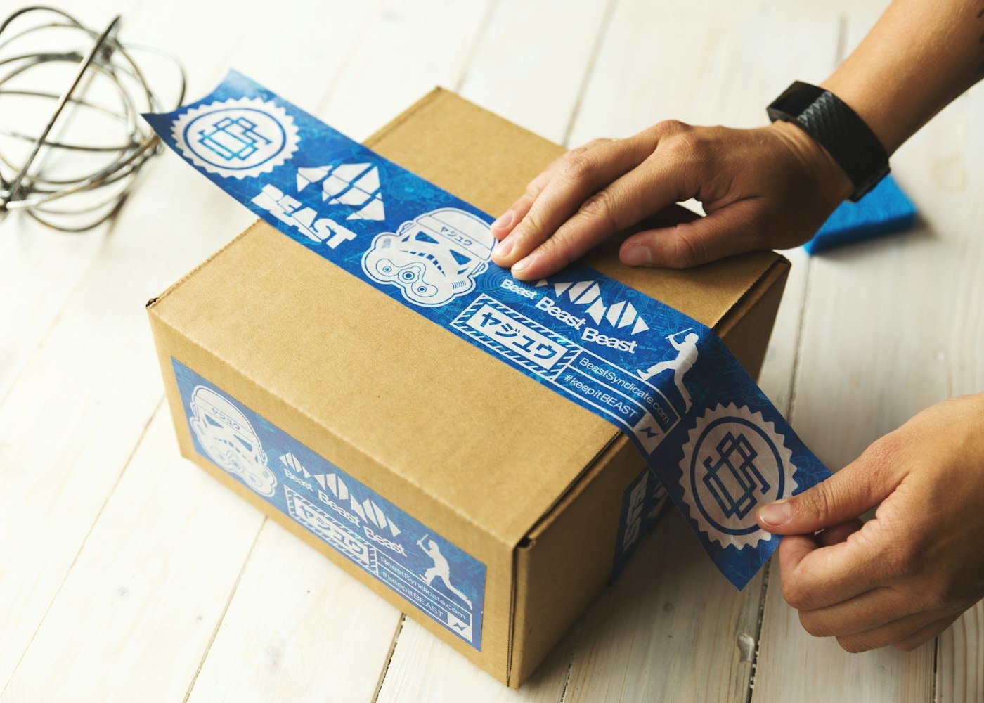 Hands taping up a branded parcel
